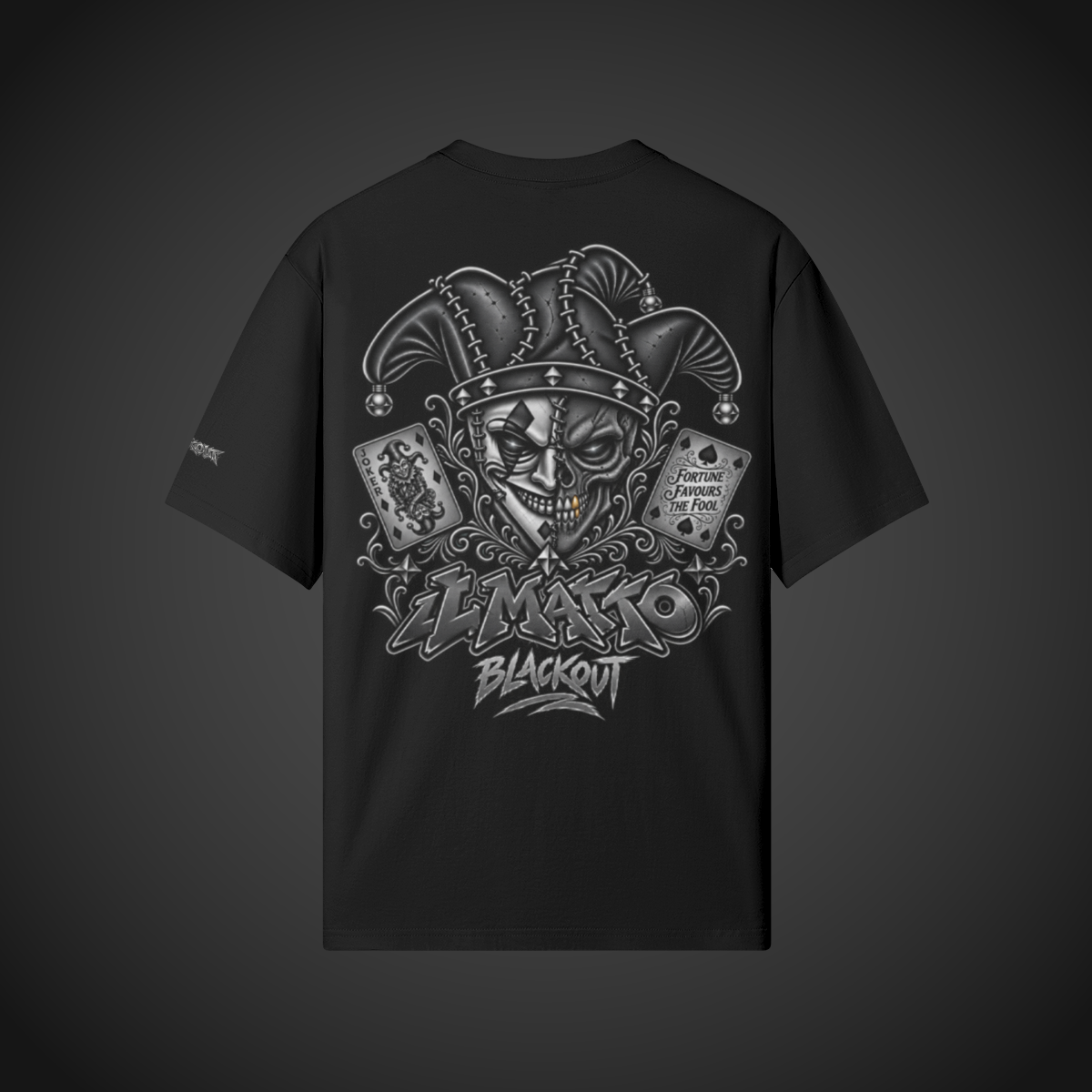 IL MATTO BLACKOUT Signature Tee in black — back supplier mockup on charcoal background, updated Fortune Favours the Fool artwork